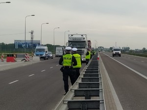 Policjanci badający trzeźwość kierowców pojazdów ciężarowych.