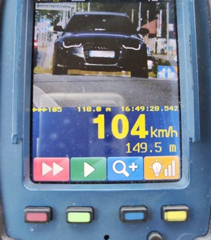 Ekran monitoria ręcznego miernika prędkości, na którym widać pojazd i wynik pomiaru.