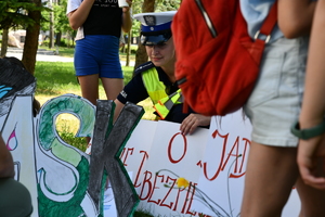 Policjantka wśród dzieci z plakatem