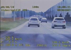 Biały samochód jadący lewym pasem i pomiar jego prędkości