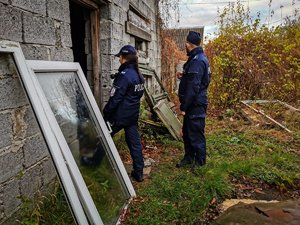 Policjanci stojący przed pustostanem