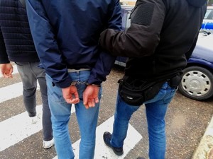 Policjanci prowadzą zatrzymanego