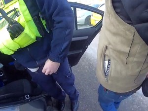 Policjant trzyma zatrzymanego mężczyznę