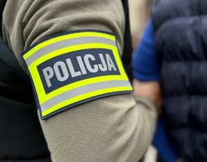 Policjant z opaską z napisem POLICJA
