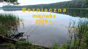 Żółty napis bezpieczna majówka na tle zbiornika wodnego