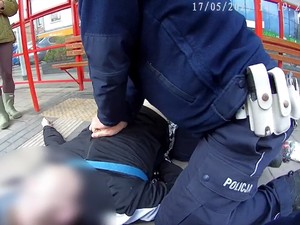 Policjant uciska klatkę piersiową leżącemu na chodniku mężczyźnie