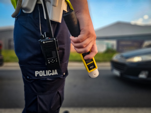 Policjant trzyma urządzenie do badania trzeźwości
