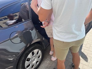 mężczyzna w kajdanach wsiadający do radiowozu