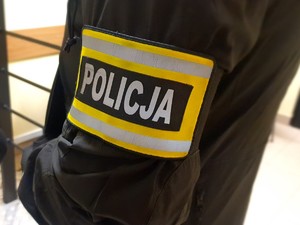 opaska z napisem policja na ramieniu policjanta