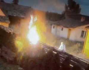 płonący płot, obok mężczyzna