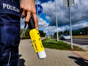 policjantka trzymająca urządzenie do badania trzeźwości