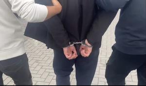 policjanci prowadzą osobę zatrzymaną