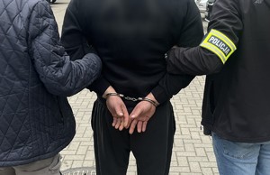 osoba zatrzymana prowadzona przez policjantów