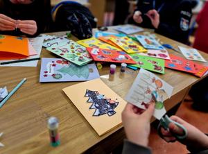 Policjantki oraz dzieci robiące kartki świąteczne policjantom na misjach