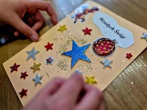 Policjantki oraz dzieci robiące kartki świąteczne policjantom na misjach