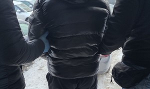 zatrzymany mężczyzna prowadzony przez policjantów