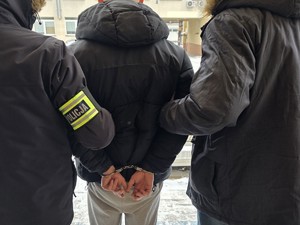 zatrzymany mężczyzna w kajdankach z policjantami
