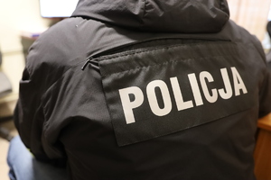 Policjant w kurtce z napisem policja