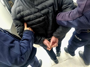 zatrzymany mężczyzna prowadzony przez policjantów