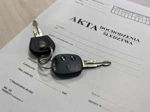 akta dochodzenia -śledztwa oraz kluczyki samochodu leżące na teczce