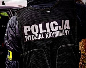 Policjant z kamizelką z napisem wydział kryminalny