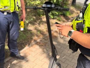 Policjanci stoją przy hulajnodze