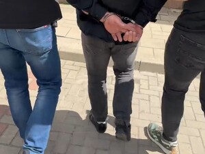 Policjanci prowadzą zatrzymanego mężczyznę