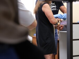Policjant pobiera odciski zatrzymanej kobiecie